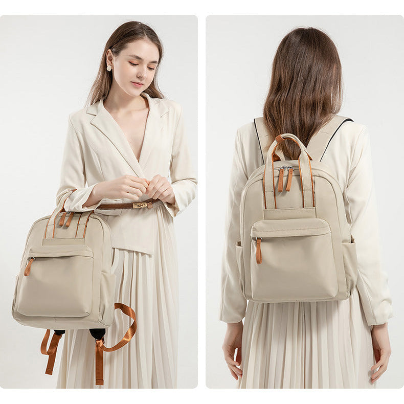 Woman holding and wearing a beige backpack with brown straps on a white background